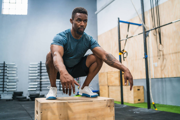 Portrait of an athletic man doing box jump exercise. Crossfit, sport and healthy lifestyle concept. - Foto, immagini