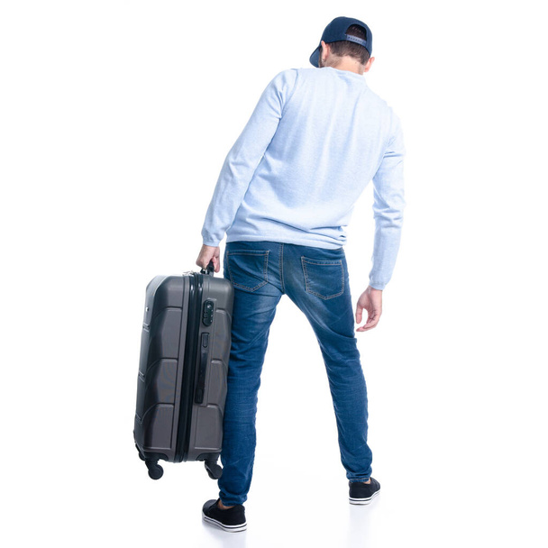 Man in jeans holding travel suitcase standing - Foto, Imagem