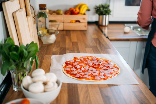 Egy nő hagyományos olasz pizzát készít. A pizza készítésének eredeti folyamata. - Fotó, kép