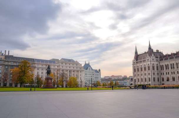 Будапешт, Венгрия - 6 ноября 2019 года: Пустая площадь Кошута со зданием венгерского парламента Оршагхаза и конной статуей Ференца Ракоци II. Исторические здания на заднем плане
. - Фото, изображение