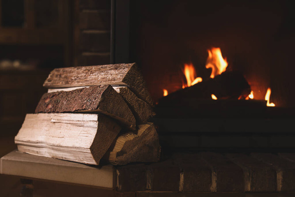 Pile of wood near fireplace indoors. Winter vacation - Foto, immagini