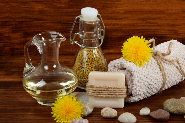 dandelion pollen and oil next to soap and towel - Фото, изображение
