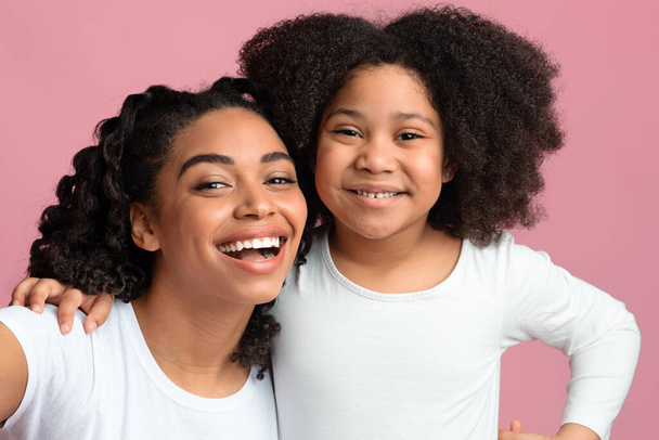 Heureuse maman noire et sa fille prenant Selfie, posant sur fond rose
 - Photo, image