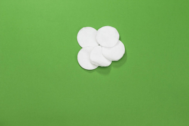 Cotton pads isolated on green background - 写真・画像