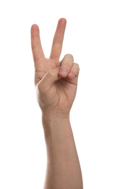 Man showing peace sign against white background, closeup of hand - 写真・画像