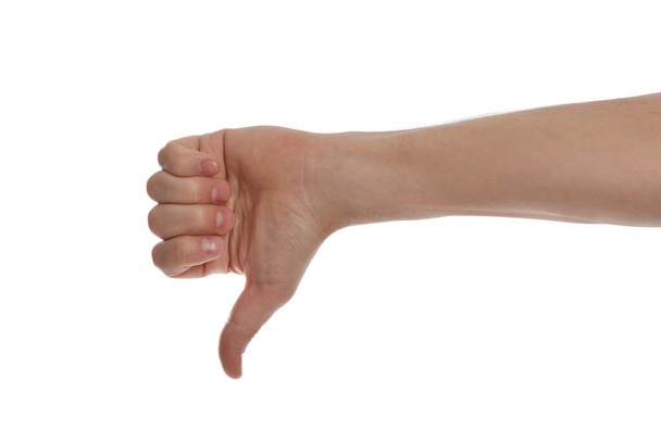Man showing thumb down gesture against white background, closeup of hand - 写真・画像
