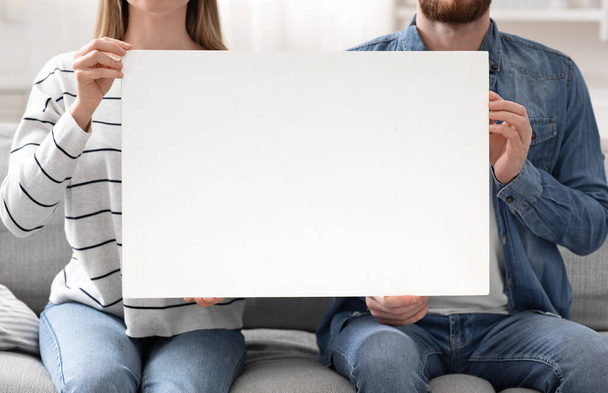 Hombre y mujer sosteniendo pancarta en blanco en casa, espacio vacío
 - Foto, imagen