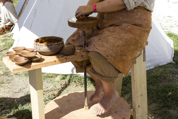 Woman makes pottery on an ancient pottery machine. - Fotoğraf, Görsel