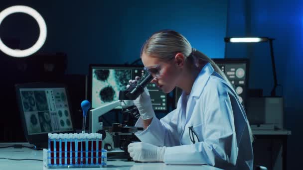 Wetenschapper in het lab. Vrouwelijke dokter doet medisch onderzoek. Laboratoriumgereedschappen: microscoop, reageerbuizen, apparatuur. Coronavirus 2019-ncov, biotechnologie, wetenschap, experimenten en zorgconcept. - Video