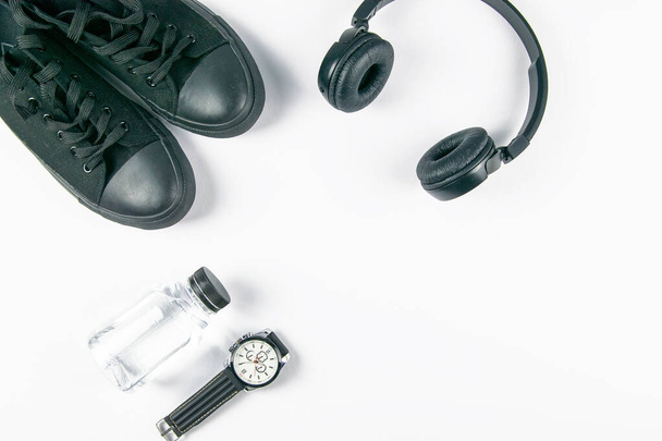 Sneakers, headphones, bottles with water and clock on a white background. Top views. - Photo, Image