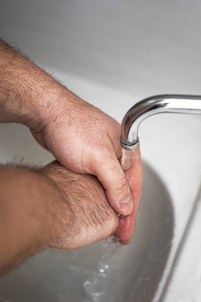 Mens hands are showing ways to wash their hands with a cleaning gel to prevent infectious diseases and prevent the virus. - Photo, Image