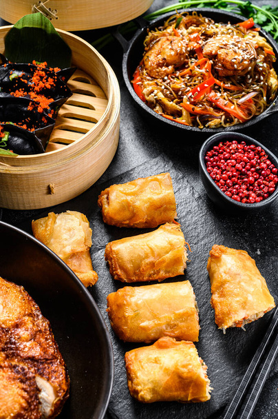 Kínai kaja. Tészta, gombóc, sült csirke, dim sum, tavaszi tekercs. Kínai konyha készlet. Fekete háttér. Felülnézet. - Fotó, kép