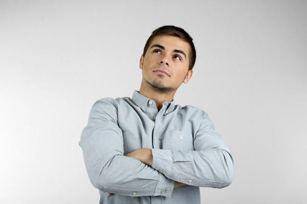 Portrait of young man on grey background - Foto, Imagen