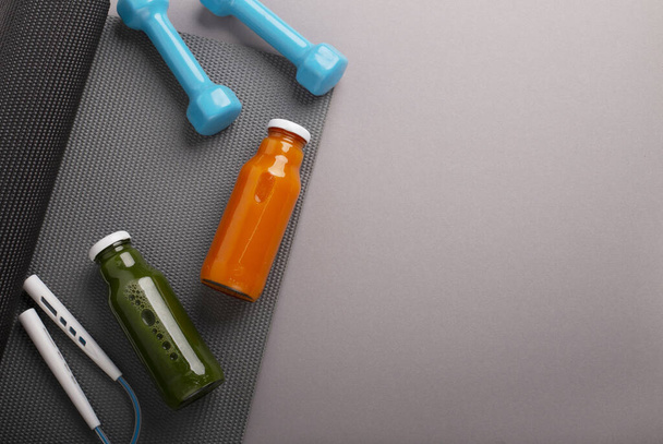 Коврик для йоги, протеиновые и детоксикационные бутылки, гантели и скакалка
 - Фото, изображение