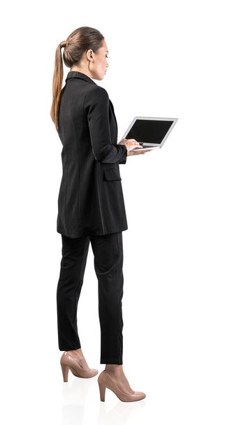 Isolated side portrait of serious young European businesswoman with long fair hair holding laptop. Concept of communication and technology - Photo, image