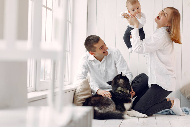 Beautiful family spend time in a bedroom with a dog - Fotografie, Obrázek