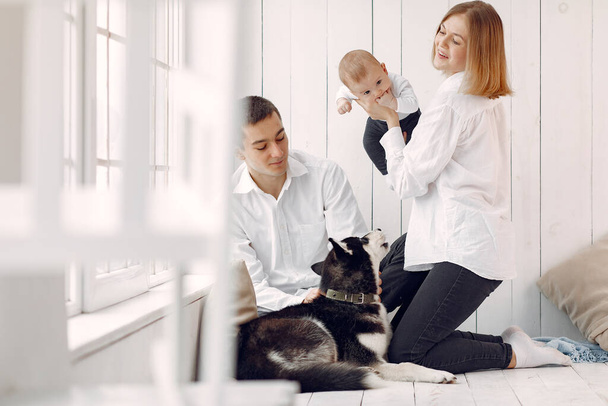 Beautiful family spend time in a bedroom with a dog - Valokuva, kuva