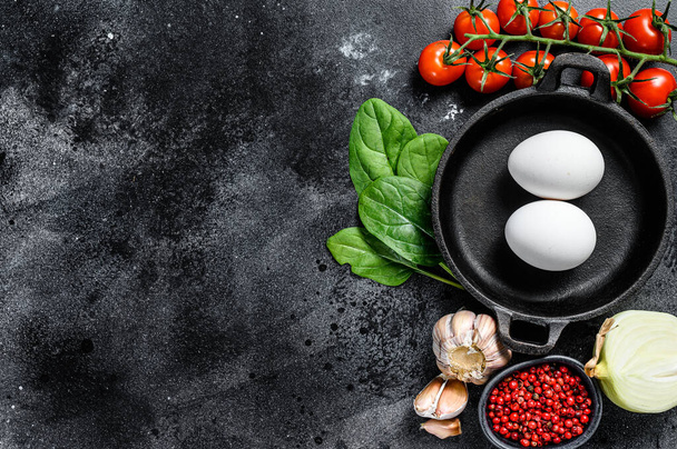 Ingredients for cooking Shakshuka. Eggs, onions, garlic, tomatoes, peppers, spinach. Black background. Top view. Copy space. - Фото, зображення
