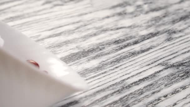 Primo piano di fagioli rossi spruzzati da una tazza di ceramica bianca su un tavolo di texture in legno. Semi marroni. rallentatore
 - Filmati, video