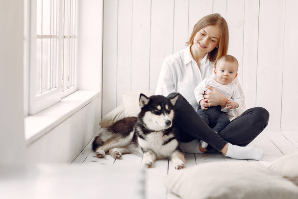 Mother and little son playing with dog at home - Фото, изображение