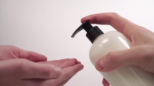youg man squeezes a soap disinfectant gel on children's hands from a white plastic container with a dispenser pump. Precautions against coronavirus infection. Preventive measures to protect against Covid-19 - Filmmaterial, Video