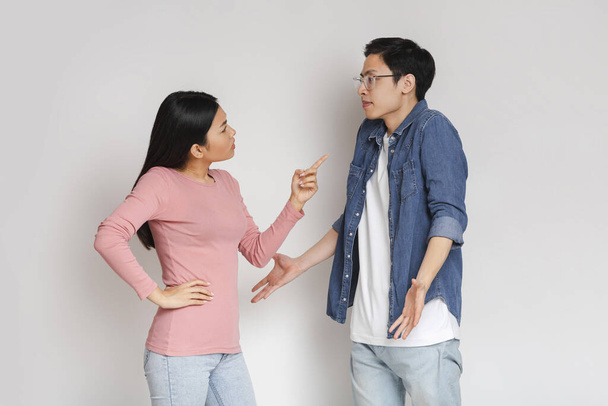 Asiatisch wütend mädchen schimpfen sie surprised boyfriend - Foto, Bild