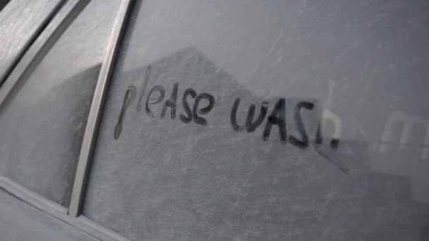 汚い車の中で書かれている:"私を洗ってください。黒い車の所有者の上に印刷します. - 映像、動画
