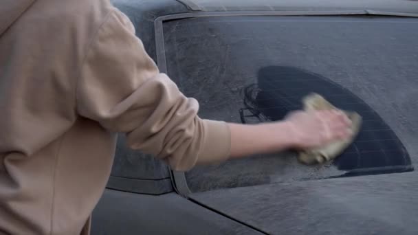 Mladá žena opláchne nápis na stroji hadrem: "Prosím, umyjte mě." Holka myje špinavý auto. Prank nad majitelem auta. - Záběry, video