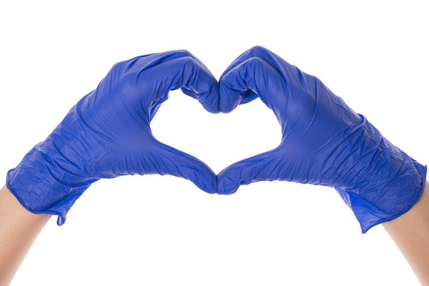 Conceito de prevenção cardiológica. Close-up foto de braços usando luvas de proteção de látex azul brilhante fazendo mostrando a forma do coração isolado sobre fundo branco
 - Foto, Imagem