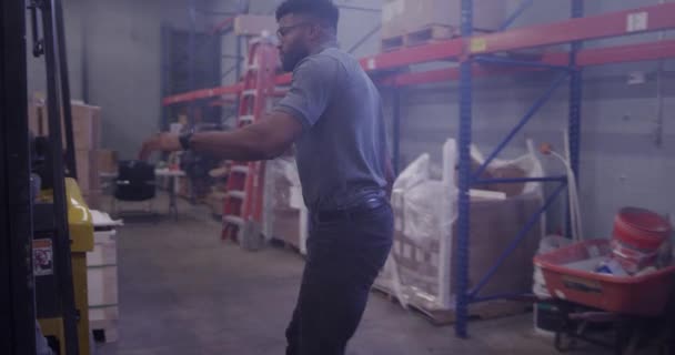 Afroamerikanischer Manager im Versandlager mit Gabelstapler - Filmmaterial, Video