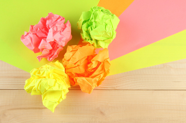 Bolas de papel amassadas coloridas no fundo de madeira
 - Foto, Imagem