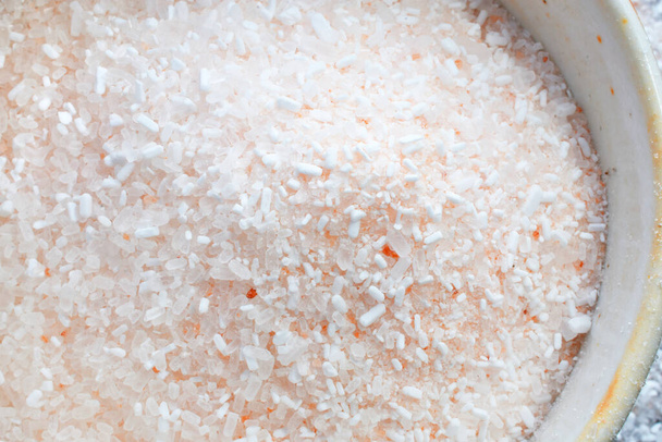 Zbliżenie wizerunek różowych himalajskich kryształów soli w jasnym kolorze ręcznie robiona ceramika miska.  - Zdjęcie, obraz