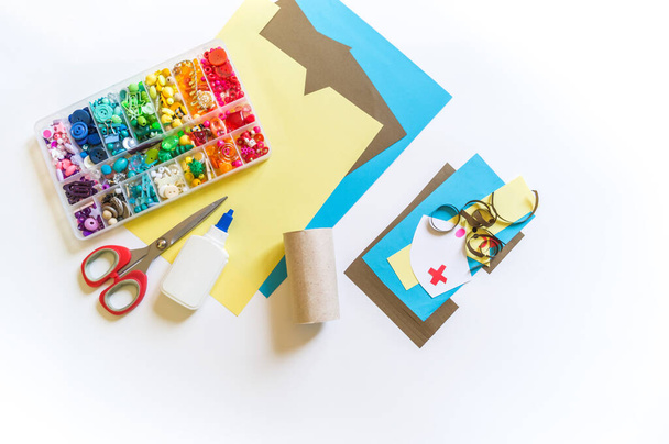 Medical health-care tag recycled paper craft stick on white background. Craft paper and cardboard bushings. Children's hands. Material for creativity. - 写真・画像