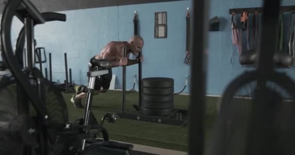Man performing sled push workout in gym - Metraje, vídeo