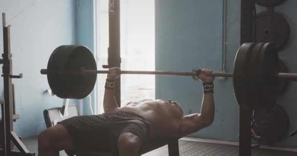 Male performing bench press in gym - Πλάνα, βίντεο