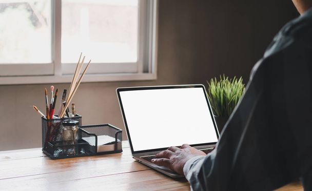 munka otthonról vagy otthon iroda koncepció miatt coronavirus járvány, egy férfi dolgozik fehér képernyős laptop - Fotó, kép