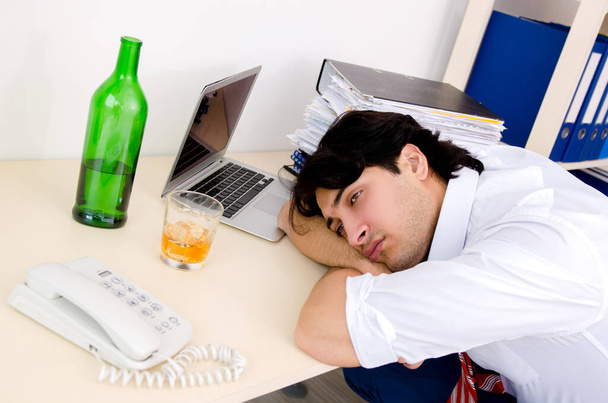 Young businessman employee drinking in the office - Φωτογραφία, εικόνα