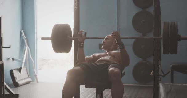 Male performing bench press in gym - Video, Çekim