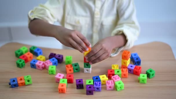 Closeup of hands of Cute little Asian 6 years old toddler boy child having fun playing with plastic blocks indoor at play in living room, Education toys for young children concept - Footage, Video
