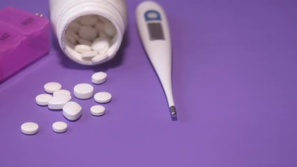 kleurrijke pillen morsen uit container op kleur achtergrond  - Video