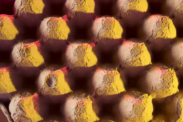 cartón o caja de huevos vacíos coloridos que muestran patrones de forma, luz y sombra
 - Foto, Imagen