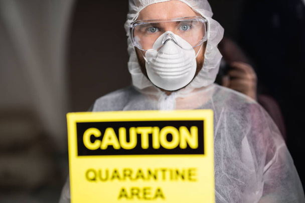Homme en combinaison blanche protectrice, masque et lunettes sur son visage. Coronavirus, pandémie, covidé-19, grippe et concept de quarantaine
. - Photo, image