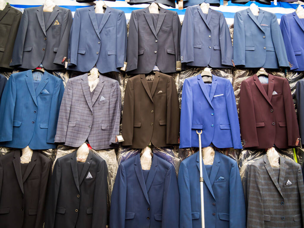 Des rangées de costumes pour hommes suspendus sur le marché
. - Photo, image