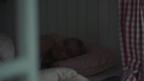 Młoda kobieta śpi w przytulnym pokoju hostel w nocy - Materiał filmowy, wideo