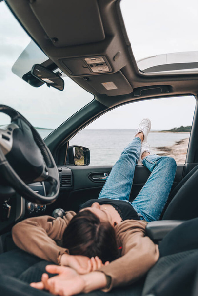 žena odpočívající v autě zaparkovaném na mořské pláži. letní dovolená - Fotografie, Obrázek