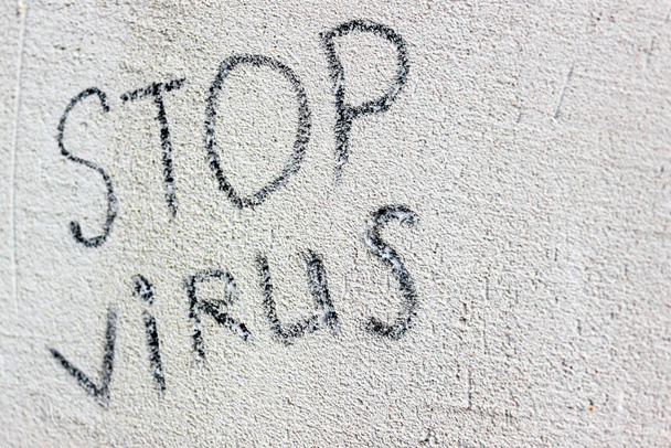 γκρι τσιμεντένια υφή καλυμμένη με ρωγμές με τη λέξη stop virus πάνω του. Κατάλληλο για διαφήμιση και μπορεί να χρησιμοποιηθεί ως φόντο. - Φωτογραφία, εικόνα