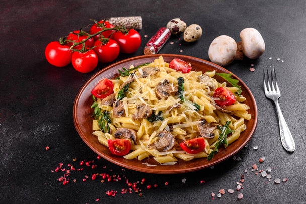 Massa com cogumelos, queijo, espinafre, rukkola e tomate cereja. Prato italiano, cultura mediterrânica
 - Foto, Imagem