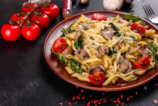 キノコのパスタ,チーズ,ほうれん草,ルッコラとチェリートマト.イタリア料理、地中海文化 - 写真・画像
