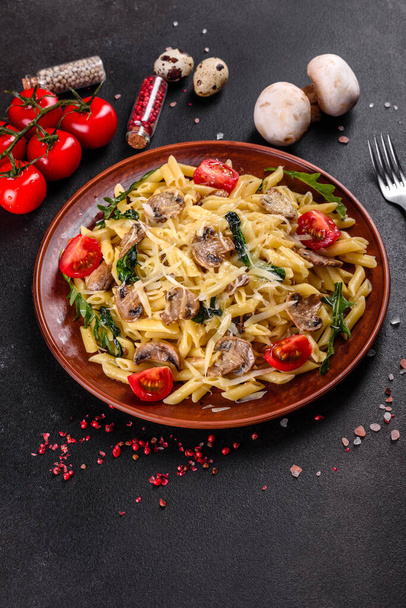 Makaron z grzybami, serem, szpinakiem, rukolą i pomidorami wiśniowymi. Kuchnia włoska, kultura śródziemnomorska - Zdjęcie, obraz