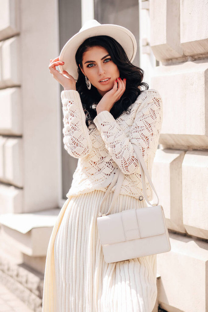 fashion outdoor photo of beautiful woman with dark hair in elegant clothes posing in the spring street - Fotoğraf, Görsel